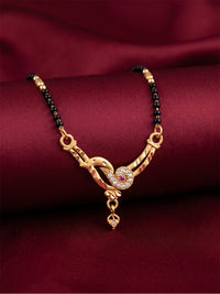 lfariya jewellery luxury gold plated black bead mangalsutra with an American Diamond square pendant and ruby red stone, styled on a white ceramic plate.