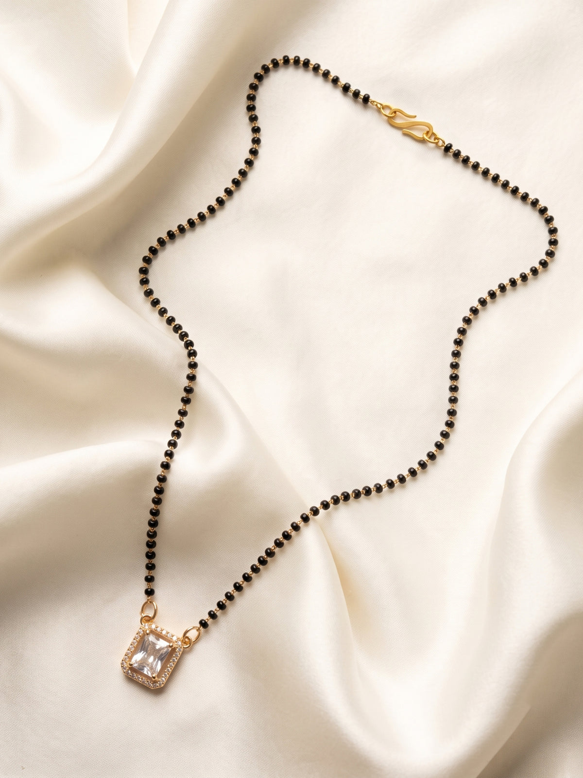lfariya jewellery premium women's mangalsutra featuring a radiant gemstone pendant with refined gold plated detailing and timeless black bead styling