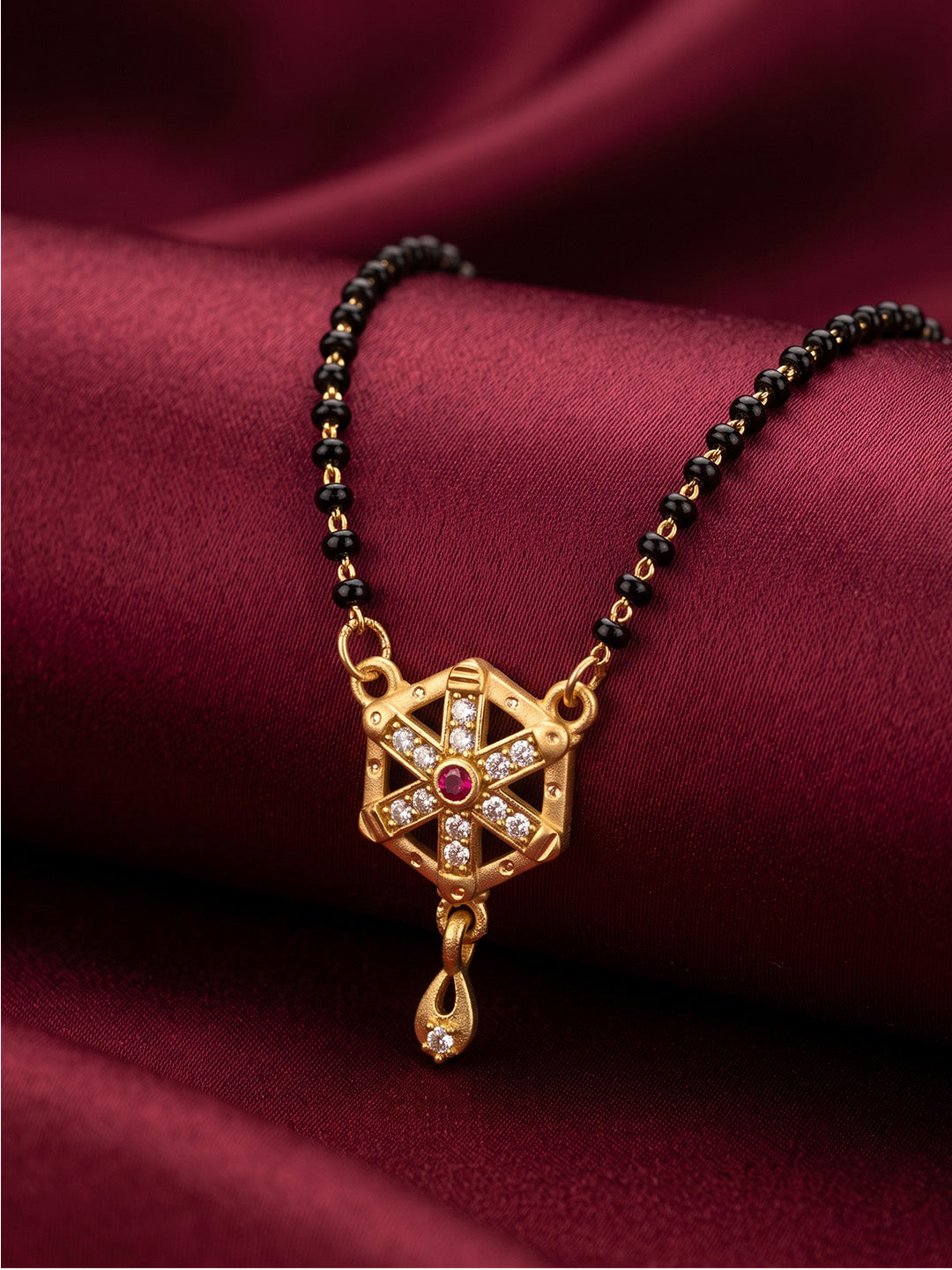 lfariya jewellery elegant gold plated mangalsutra necklace displayed on a luxury white ceramic plate, featuring a square ruby gemstone pendant, sparkling stone detailing, black bead chain and premium handcrafted finish for women.