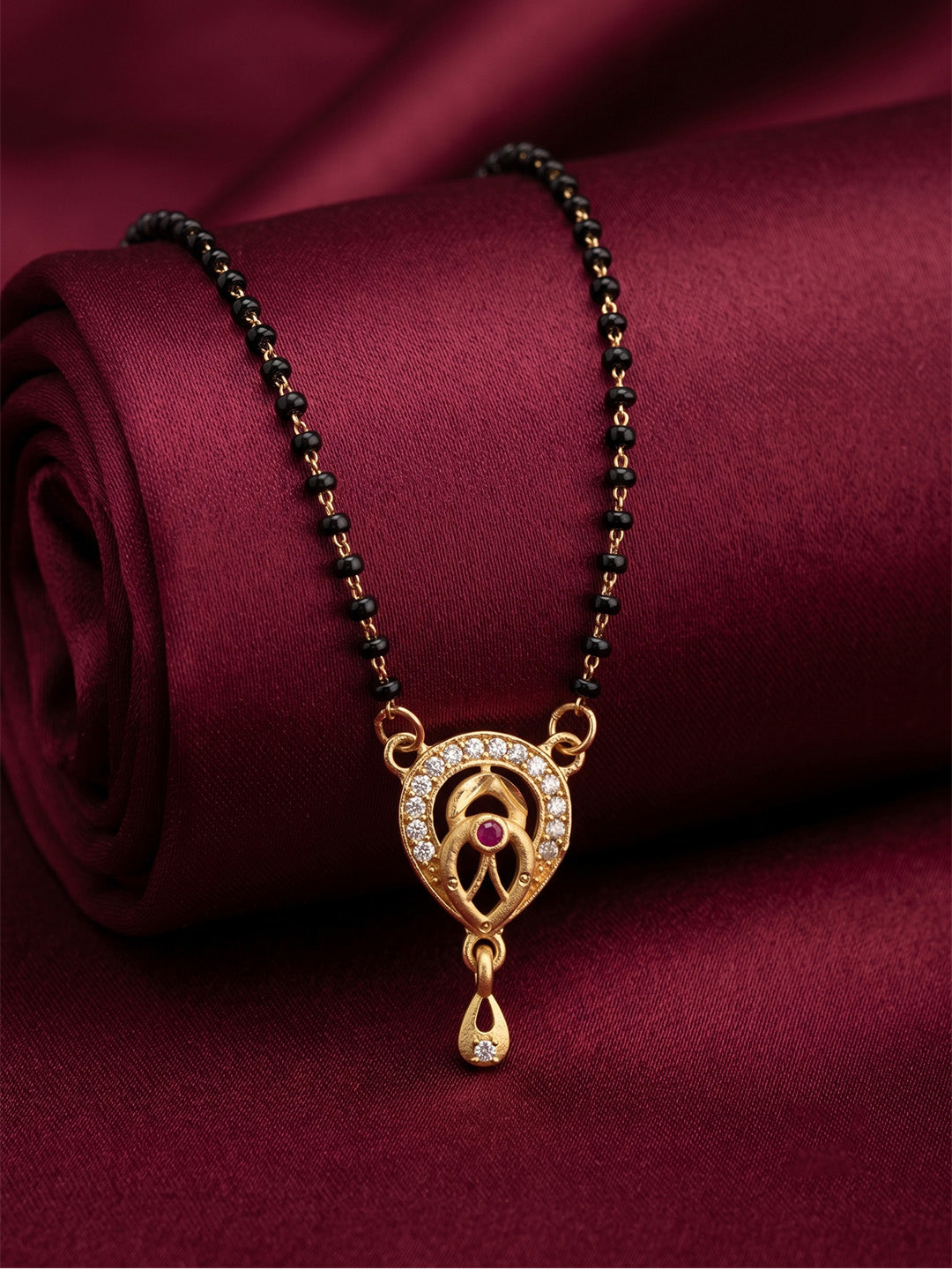 lfariya jewellery beautifully crafted gold plated necklace featuring a sparkling square pendant, vibrant gemstone center and elegant black bead chain displayed on a decorative ceramic plate