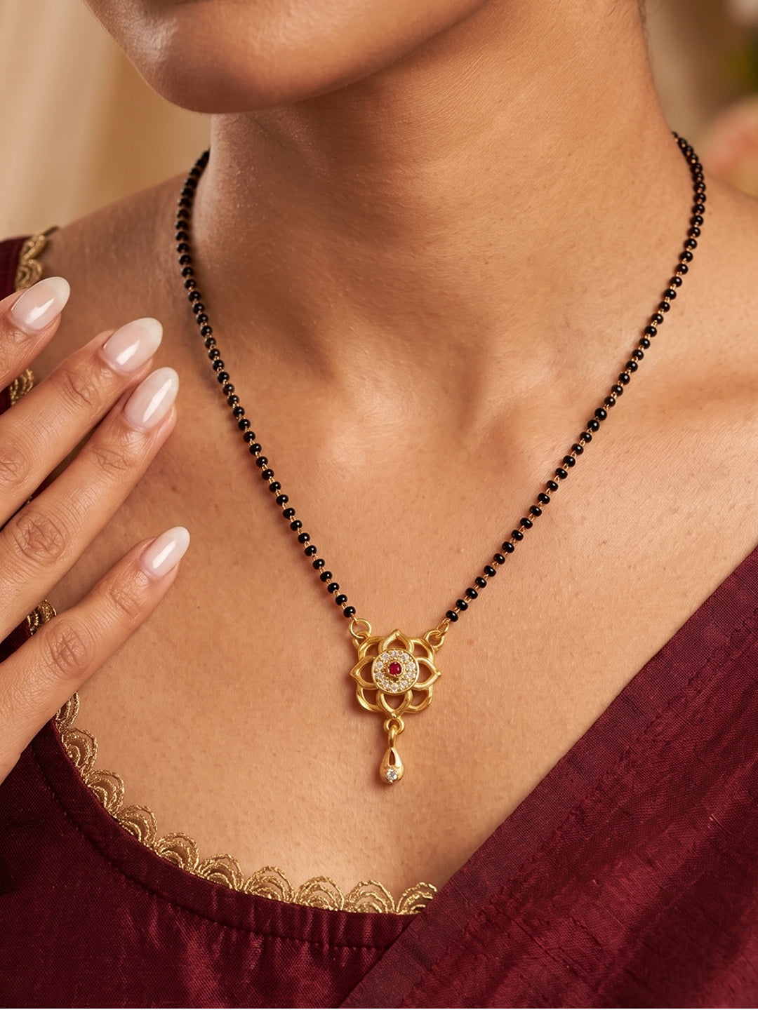 Elegant lotus flower gold plated mangalsutra pendant with sparkling CZ stones, black bead chain and drop charm for women, suitable for weddings, festivals and daily wear.